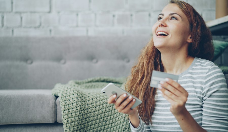 Woman smiling at her phone at home