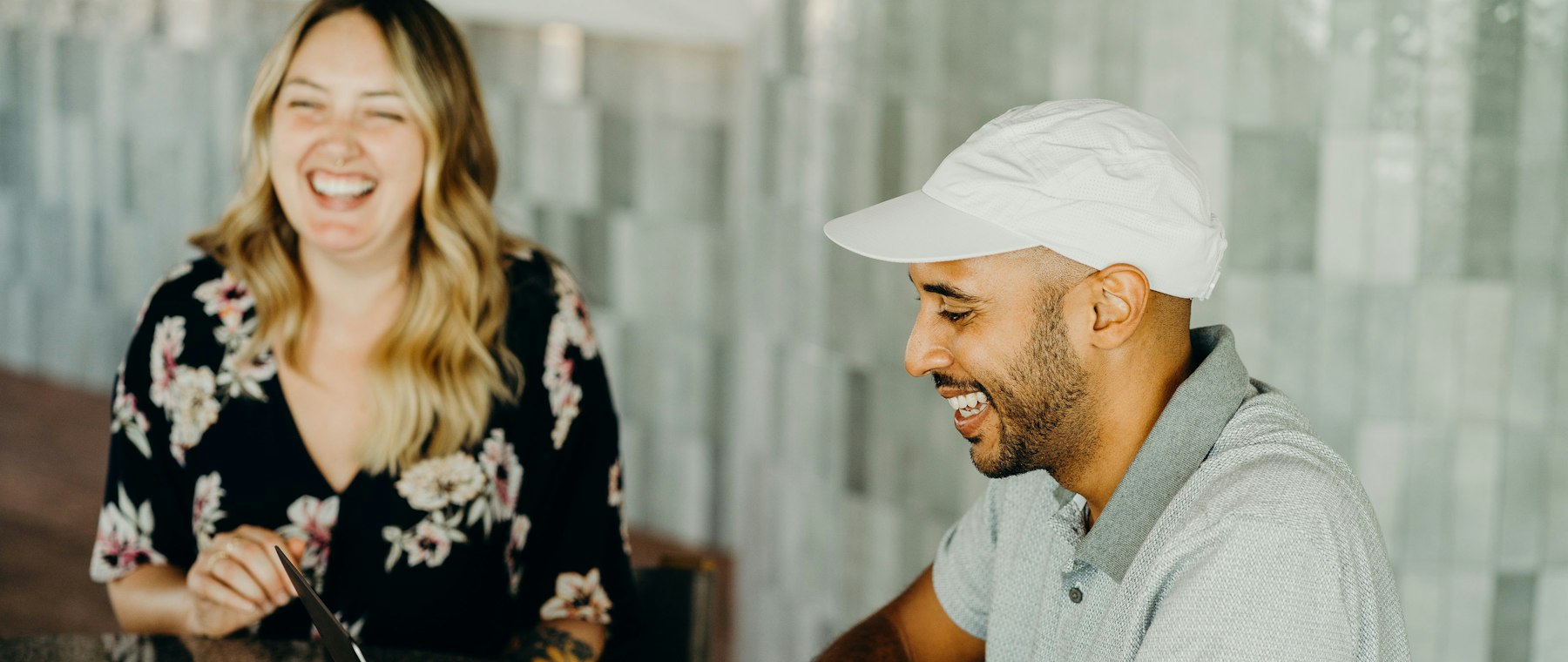 Two colleagues laughing over a laptop